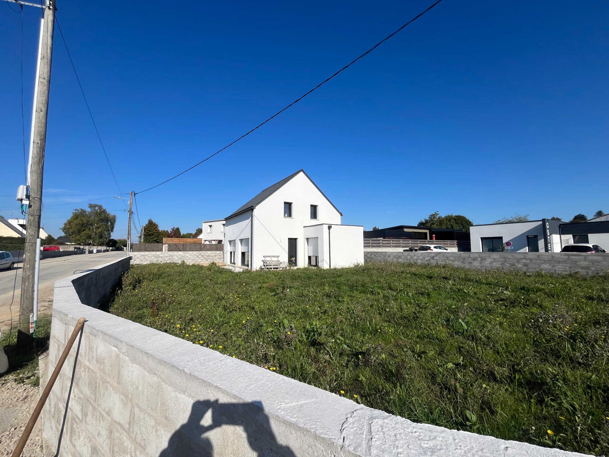 Vue d’ensemble de maison contemporaine AJY Maçonnerie implantée sur grand terrain en bord de route en Bretagne.